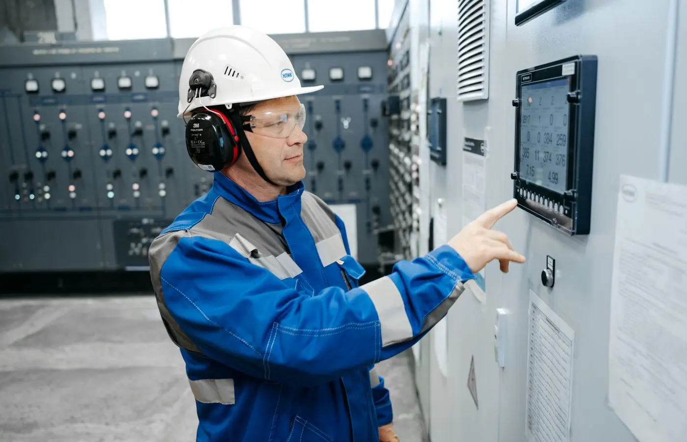 Tecnico al pannello di controllo di un impianto industriale